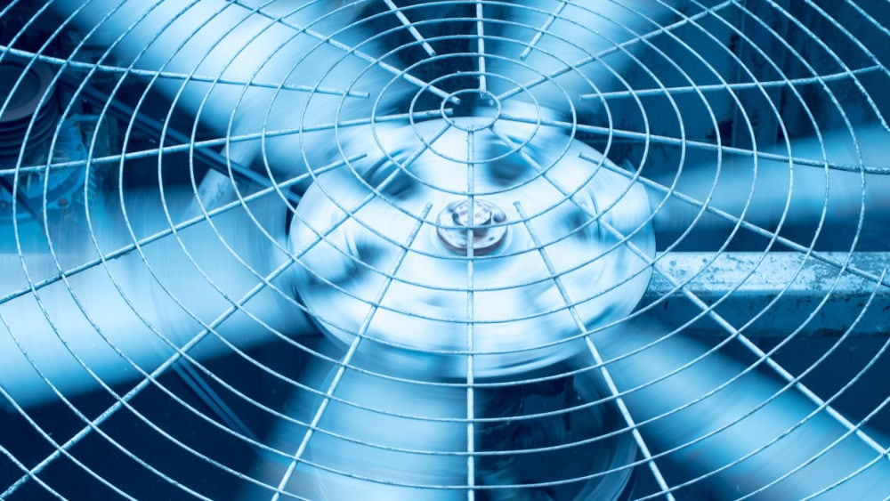 Close-up of air conditioner fan blades spinning.