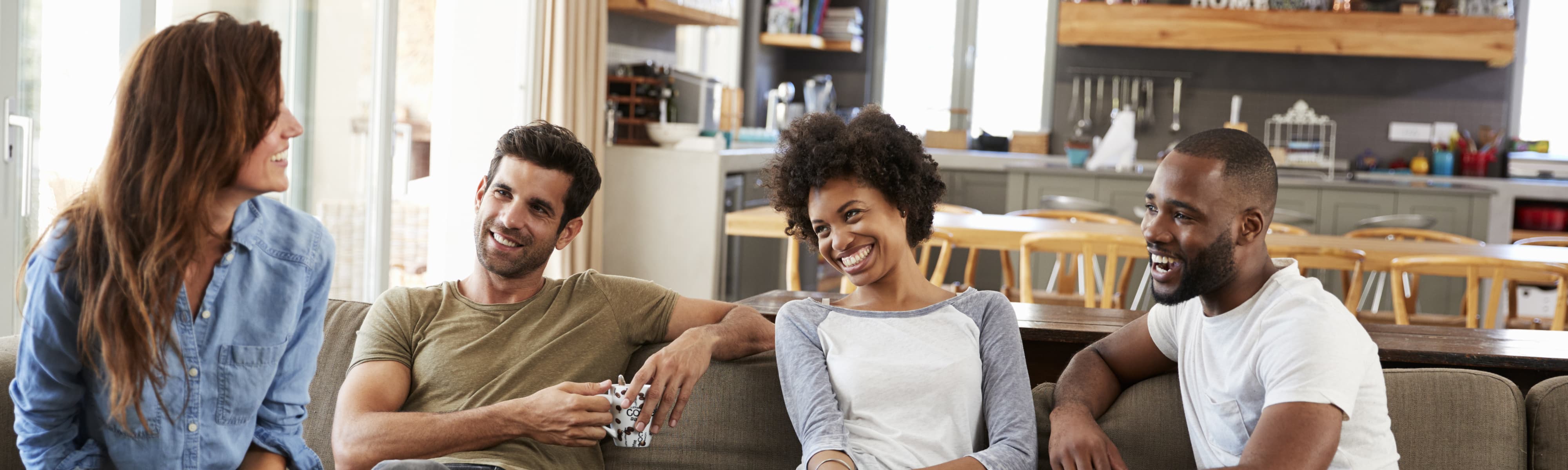 Two couples talking at home.