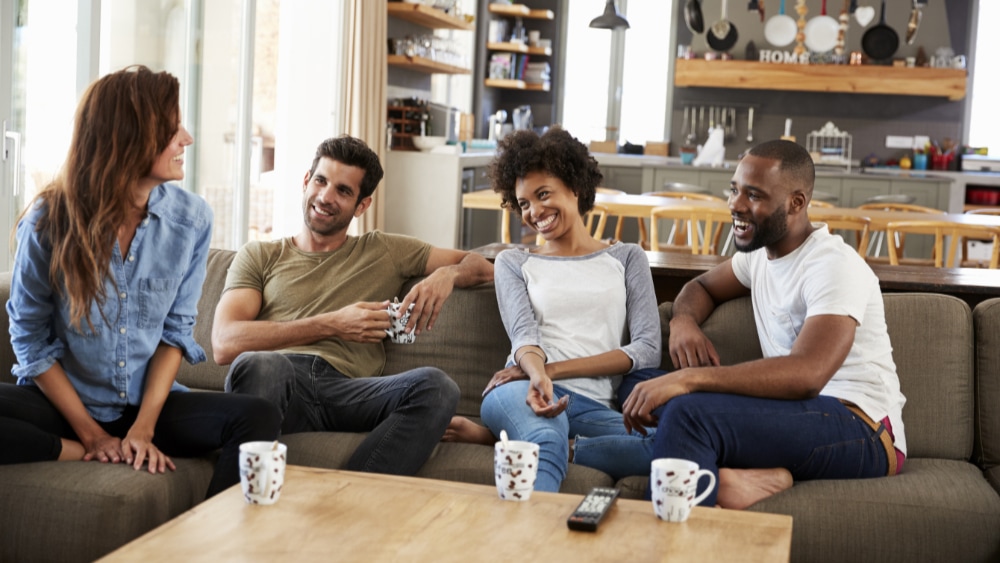 Two couples talking at home.