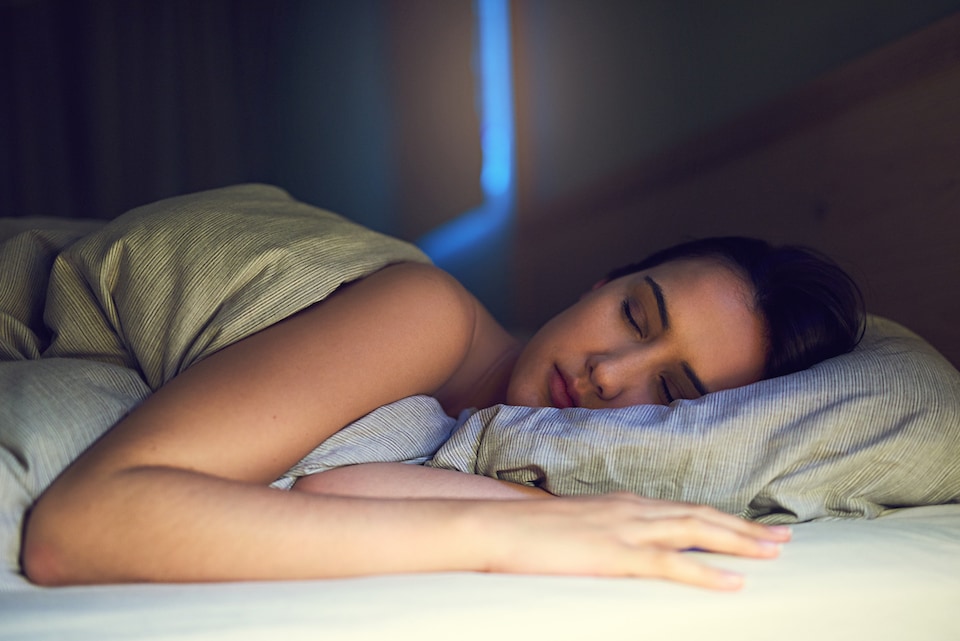 Woman sleeping comfortably after using her ac while sleeping at night