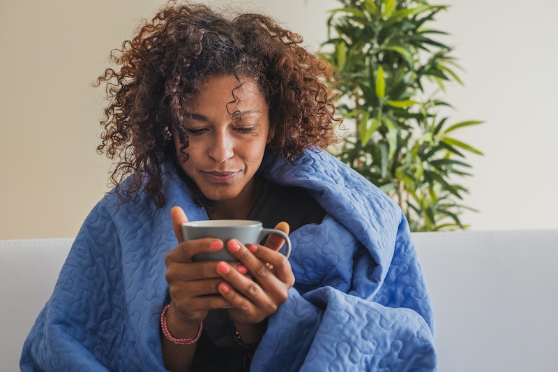 Black woman drinking hot tea and feeling comfortable