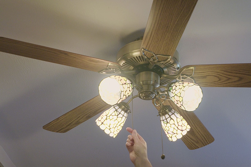 hand turning on a fan