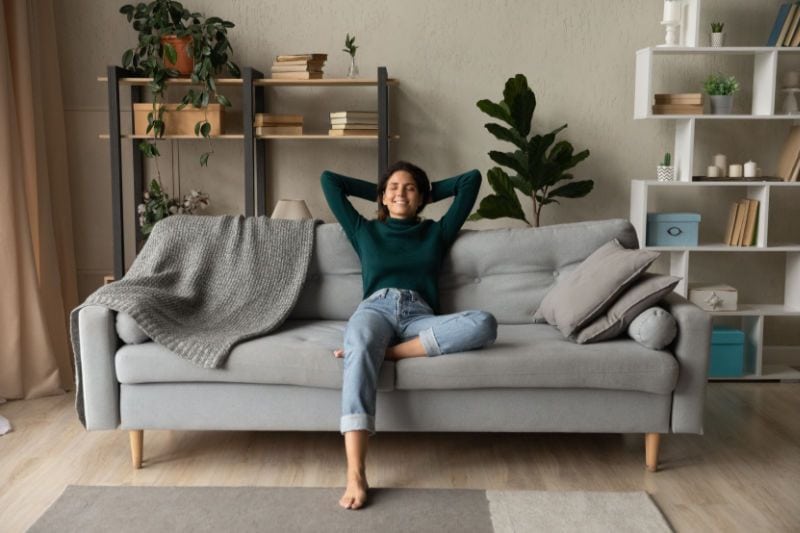 Image of someone sitting on a couch. How a Whole-House Humidifier Keeps You Healthy.